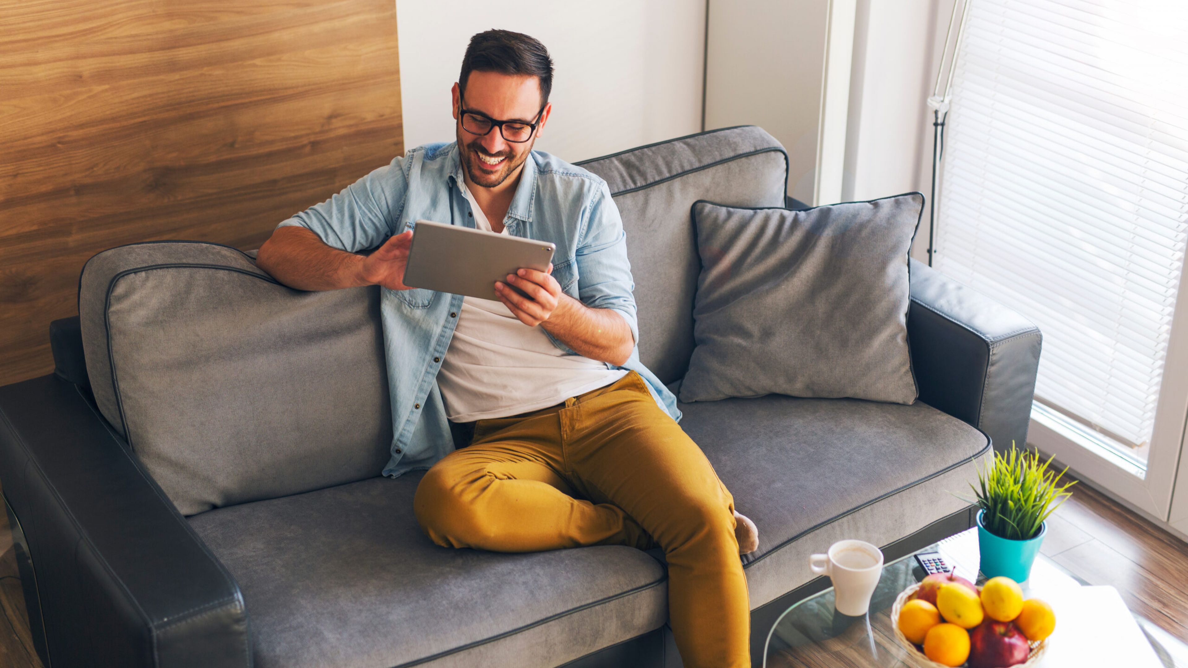 The Austin Apartment HomesThe Austin Apartment Homes Smiling young man relaxing at home and using tablet