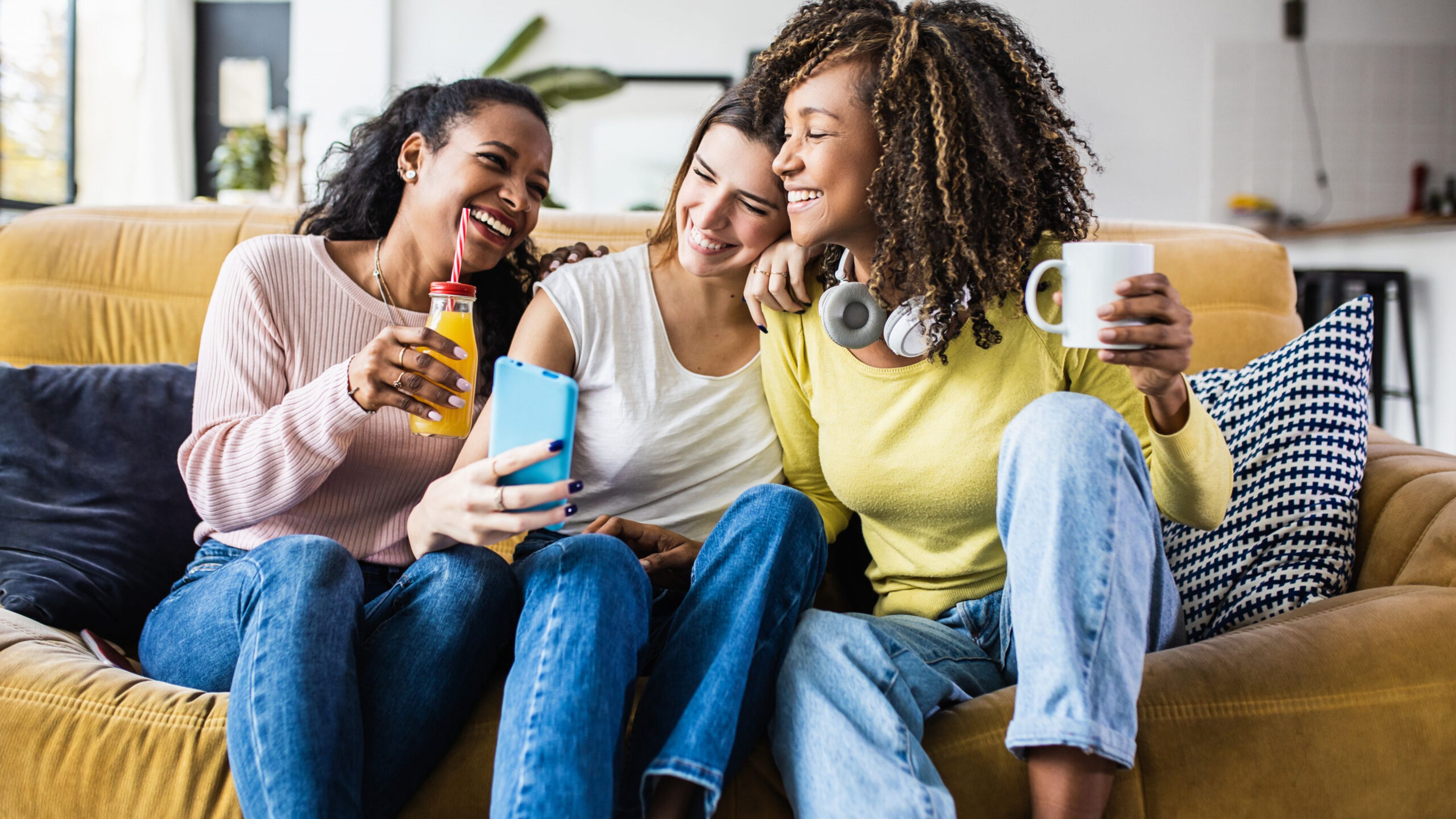 The Austin Apartment HomesThe Austin Apartment Homes Three women sitting on a couch, each focused on their smartphones, engaged in conversation and sharing moments.